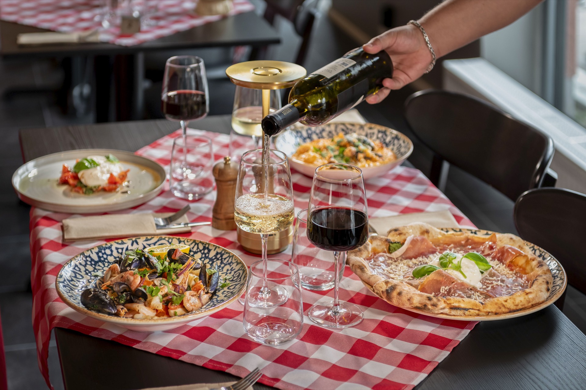 Table set with pizza, pasta, risotto and wine at Bistrot di Famiglia